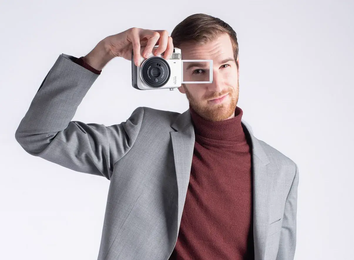 Ugo avec un H présente un Polaroid pendant un événement