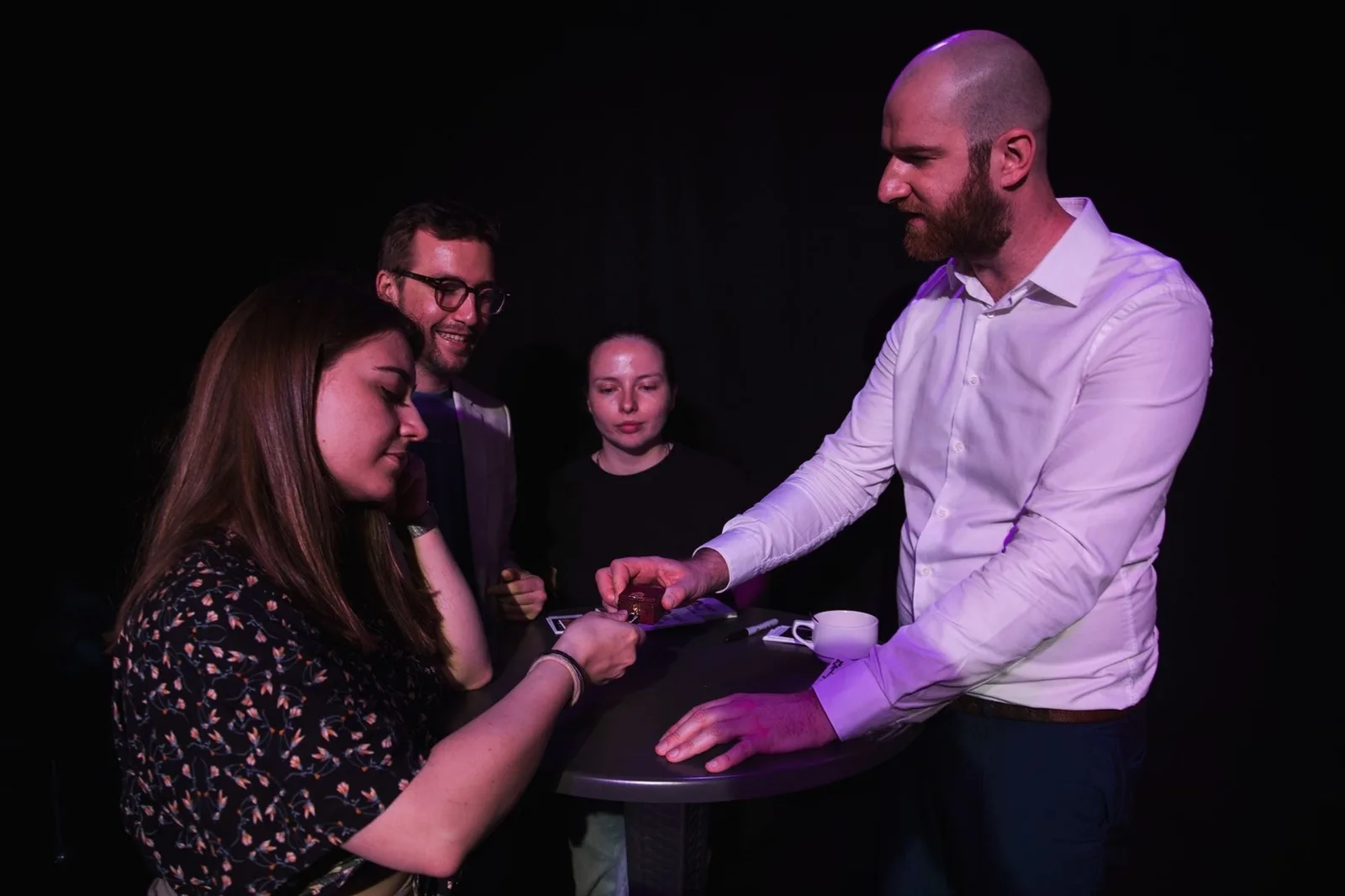 Une spectatrice manipule un objet sur la table sous les yeux d'Hugo