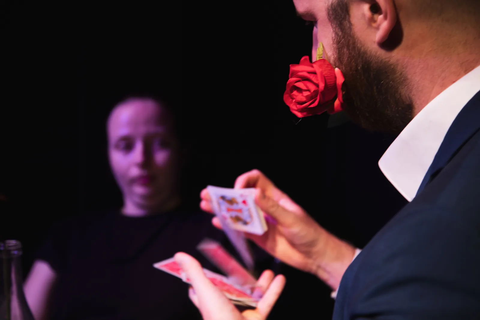 Hugo, une rose entre les dents, distribue des cartes devant une spectatrice
